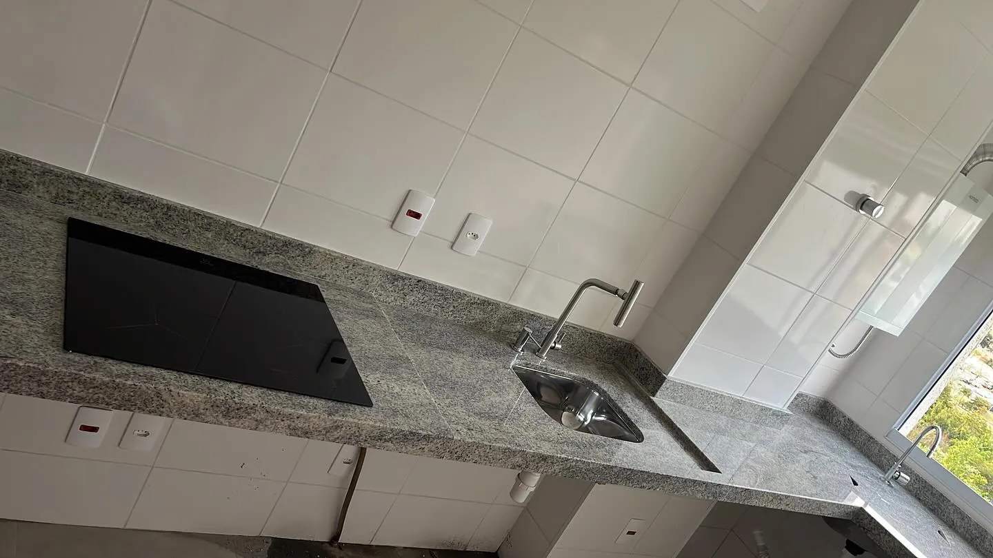 Cozinha planejada com bancada de granito e tampo de tanque esculpido